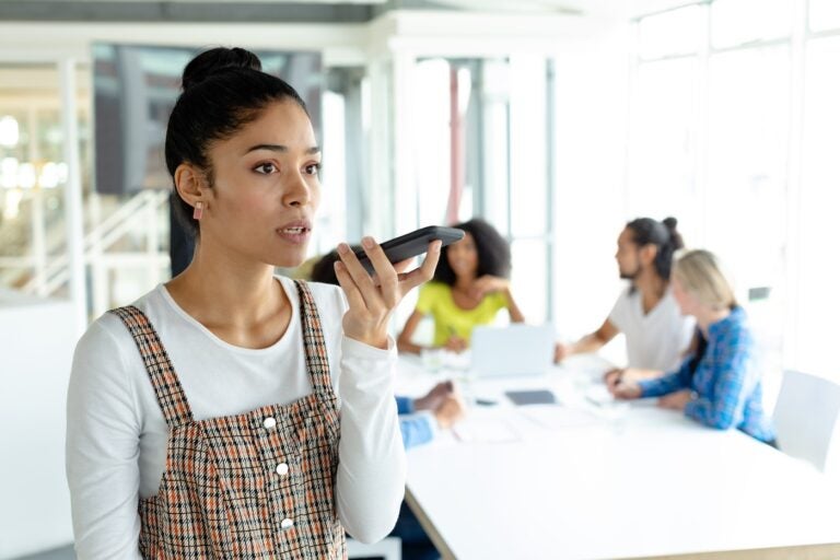 Stock image of a business pro talking into a mobile device.