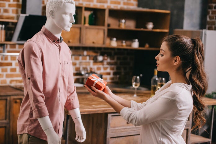 Woman accepts a gift from a robot in a men's shirt