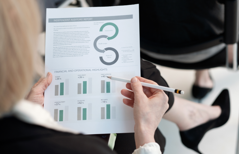 Woman holding a pencil while reading a report.