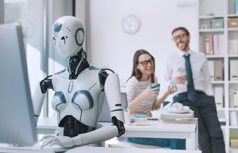 A humanoid working with two employees laughing together in the background.