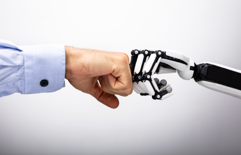 Human and robot hand making a fist bump.