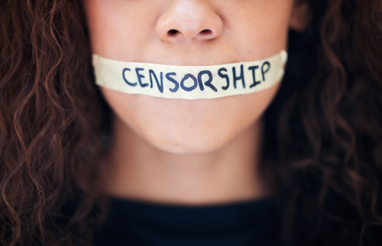 A woman's mouth covered with a tape with censorship inscription.