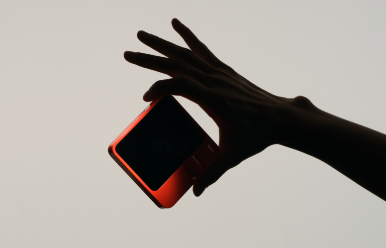 Semi silhouette of a hand holding a device.